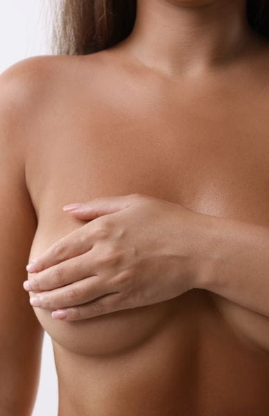 Naked woman covering her breast on white background, closeup